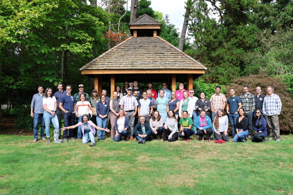 A group of more than 40 people from the Science Section stand outside next to a gazebo smiling.
